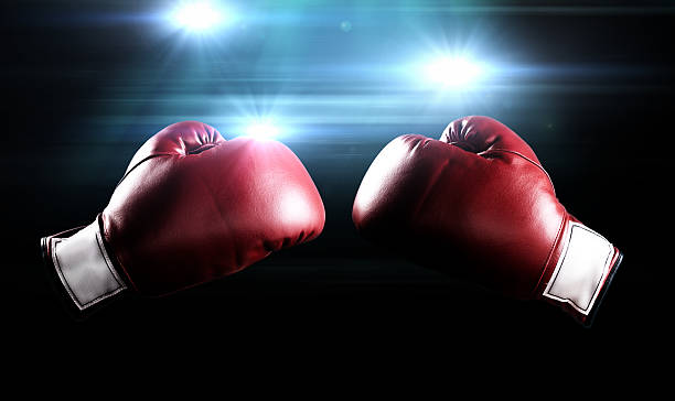 Boxing gloves and flashes Red boxing gloves with the glow of flashes in the background. boxing glove stock pictures, royalty-free photos & images