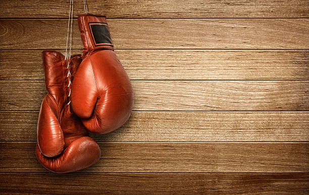 Boxing gloves hanging Hang up the gloves, old leather boxing gloves hanged on wooden wall boxing glove stock pictures, royalty-free photos & images
