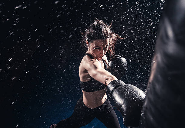 Boxing power Young woman boxing at the punching bag defending sport stock pictures, royalty-free photos & images
