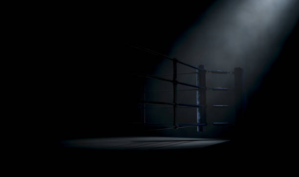Boxing Ring Corner A dramatic closeup of a dimly spotlit corner of a boxing ring surrounded by ropes on a dark isolated background - 3D render boxing ring stock pictures, royalty-free photos & images