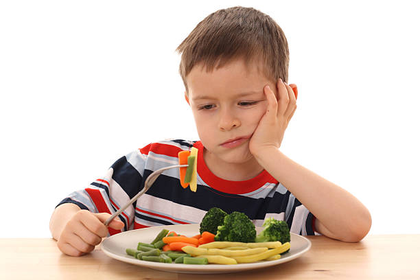 boy and cooked vegetables stock photo