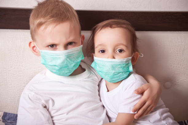 Boy and girl, a children in a medical mask. The concept of an epidemic, influenza, protection from disease, vaccination. stock photo