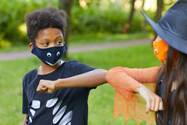 Boy and girl playing outdoors African boy in costume playing with his friend in the park outdoors costume stock pictures, royalty-free photos & images