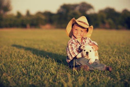 A young American boy with his dog on the farm.