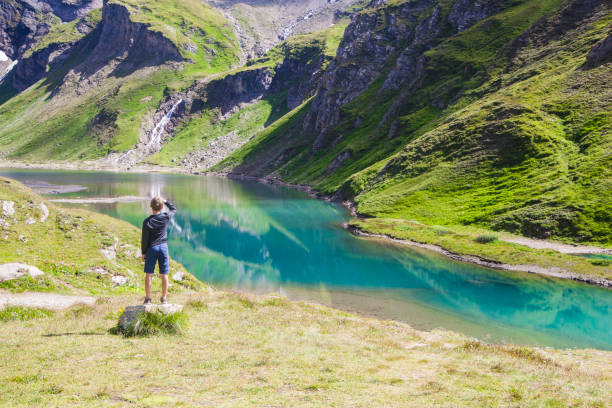 A boy at the alpine lake A boy watching the lake called Nassfeld Speicher in Hohe Tauern National Park in Austria hohe tauern range stock pictures, royalty-free photos & images