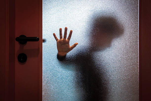 Boy Behind Glass Door Blurred sad boy leaning open hand against glass door. abuse stock pictures, royalty-free photos & images
