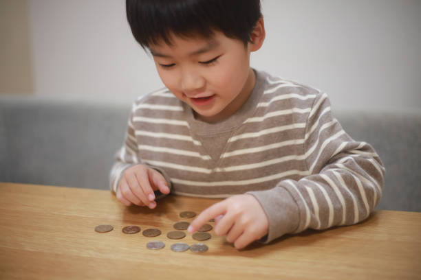 Boy counting coins stock photo