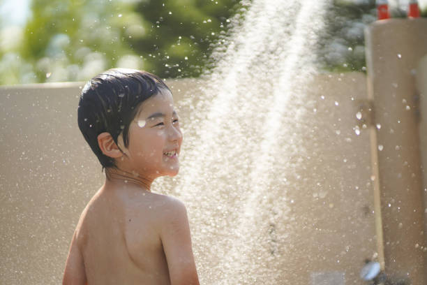 Boy frolicking in the shower stock photo