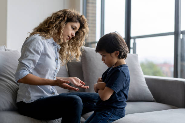 Boy having a tantrum at home and mother trying to talk to him Latin American boy at home having a tantrum at home and mother trying to talk to him - lifestyle concepts child behaving badly stock pictures, royalty-free photos & images