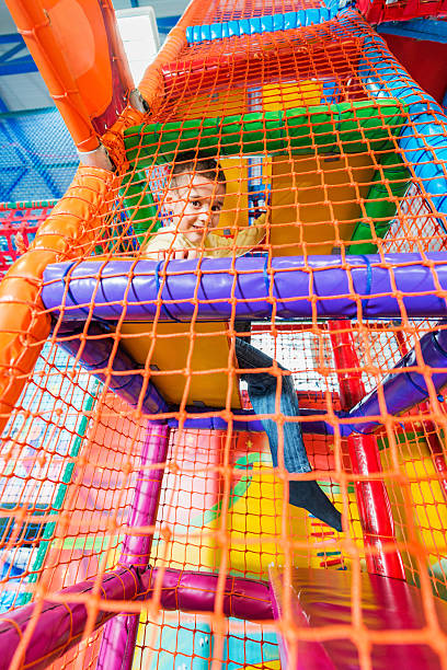 Boy in a playroom. Little boy playing in an indoor playground.   indoor playground stock pictures, royalty-free photos & images