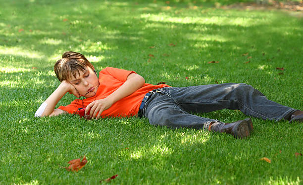 Boy in park listening to mp3 player