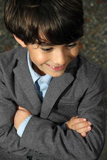 Boy is folded handed looking away and smiling, stock photo
