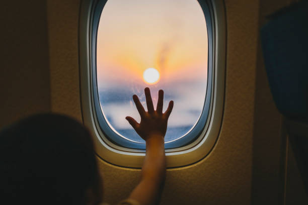 飛行機の窓から景色を見ている少年 - 飛行機 ストックフォトと画像