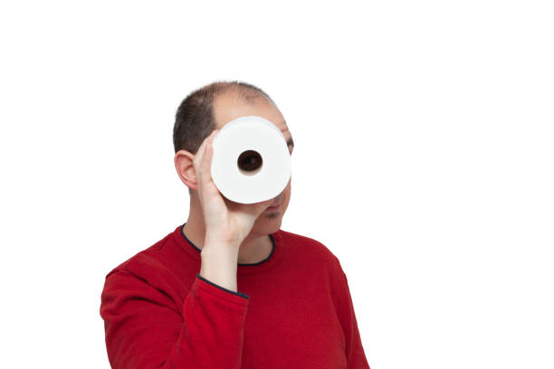 A boy looking through a roll of toilet paper stock photo