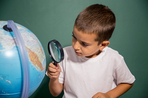 boy-looking-through-magnifying-glass-at-