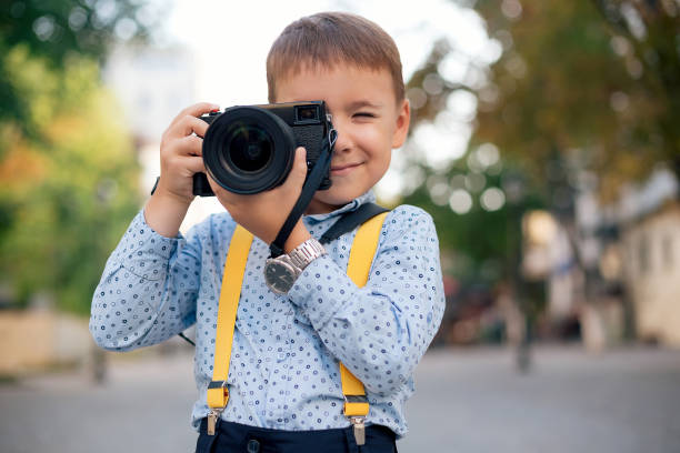 Boy makes pictures on film retro style digital camera stock photo