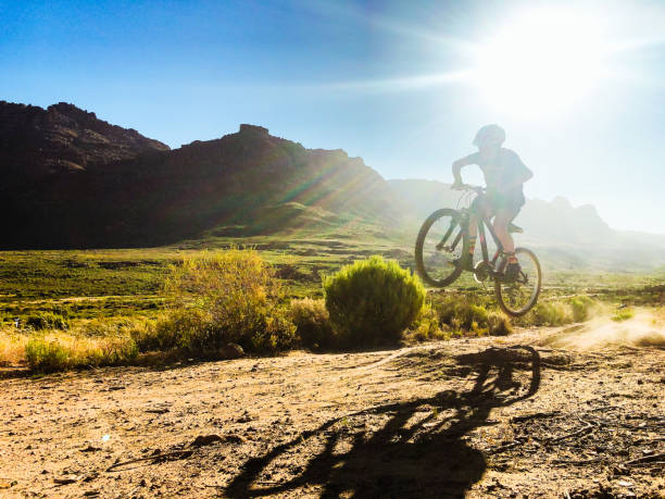 Boy on Mountain Bike Jumping on pipe track in the mountains Silhouette stock photo