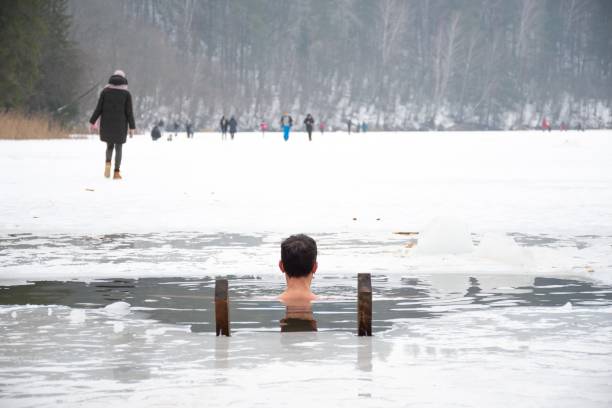 pojke eller man som badar och simmar i det kalla vattnet - ice bath in natural frozen lake bildbanksfoton och bilder