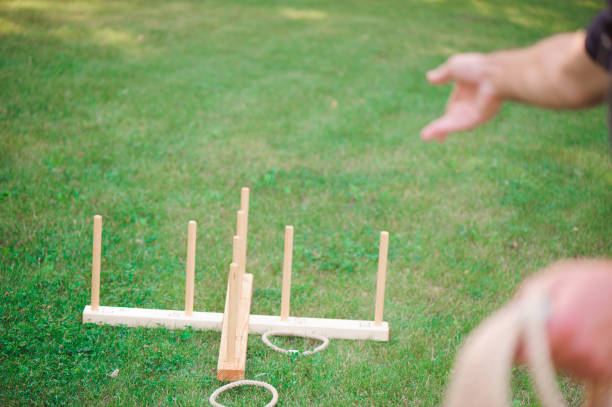 Boy playing a game throwing rings outdoors in summer park stock photo