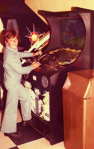 Boy playing vintage video games Vintage image of a boy playing in an old vide ogame machine. video game photos stock pictures, royalty-free photos & images