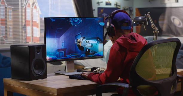 Boy playing with a video game Medium shot of a boy playing with a first-person shooter video game medium shot stock pictures, royalty-free photos & images