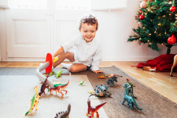 Мальчик, играющий с игрушезями динозавров