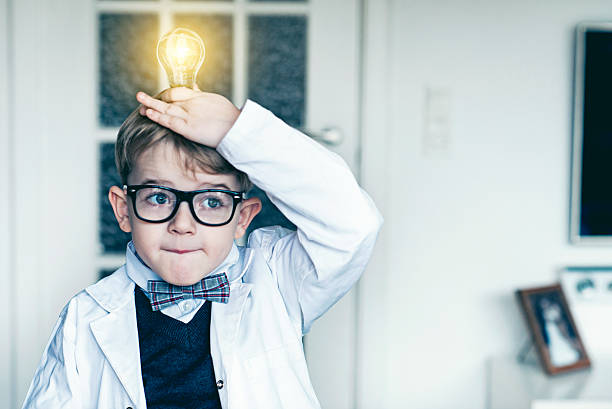 少年は電球の上に頭となるアイデア - 子供　発明 ストックフォトと画像