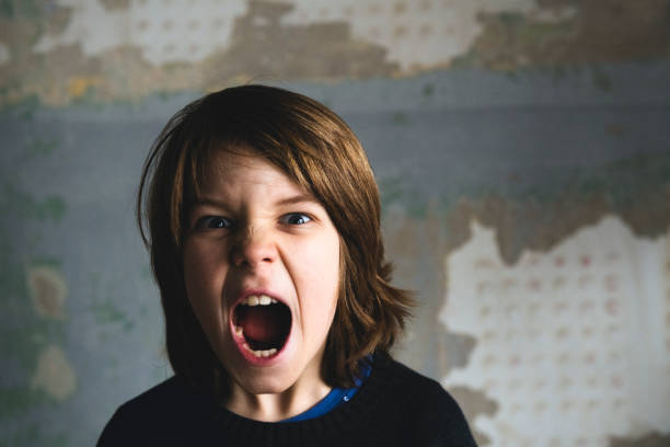 Boy screaming against rusty wall stock photo