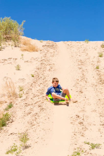 boy sliding down sand dune w: little sahara recreation area - has san hawkins zdjęcia i obrazy z banku zdjęć