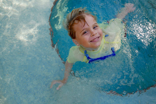 Boy smiling while swimming in a hot tub stock photo
