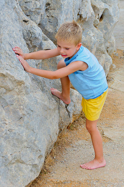 Boy starts climbing the wall stock photo