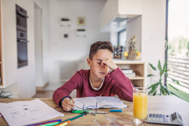 Boy tired of doing math One man, young boy is tired of doing homework, sitting at the table. boys glasses stock pictures, royalty-free photos & images