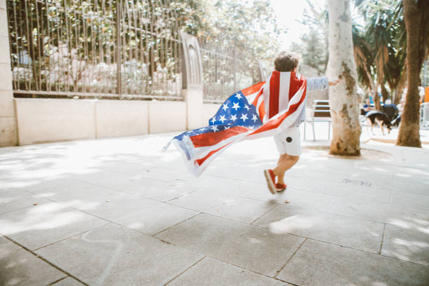 мальчик, идущего с американским флагом - july 4 стоковые фото и изображения