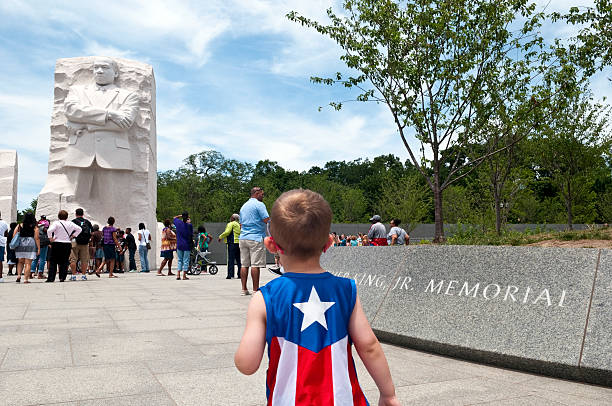 Two heroes: Captain America meets MLK Jr. A boy wearing a Captain America shirt walks toward the sculpture at the Martin Luther King Jr Memorial in Washington D.C. mlk memorial stock pictures, royalty-free photos & images