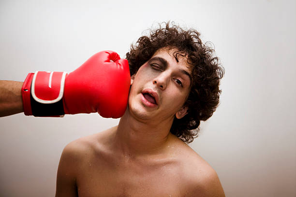 A boy with a bruised faced being punched by a boxing glove born to be a boxer? I dont' think so.... black eye stock pictures, royalty-free photos & images