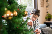 ダウン症候群を持つ少年がクリスマス ツリーを飾る