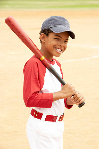 Boy with red baseball bat over shoulder on court Young Boy Playing Baseball  batting sports activity stock pictures, royalty-free photos & images