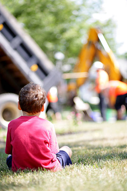 Boy with special needs watches the construction worksite stock photo