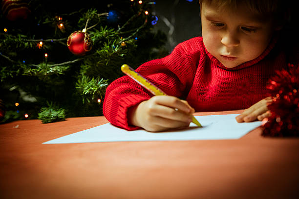 Boy writing letter to Santa stock photo