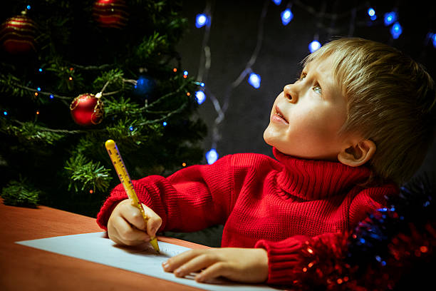 Boy writing letter to Santa stock photo