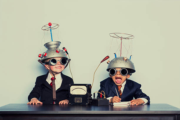 boys dressed as businessmen wearing mind reading helmets - maatpak stockfoto's en -beelden