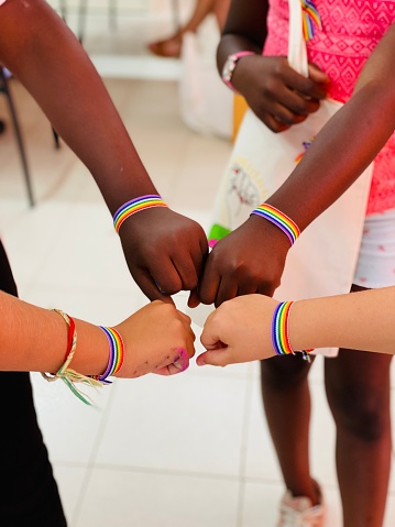 Arms with bracelets in the colors of the lgtbi flag