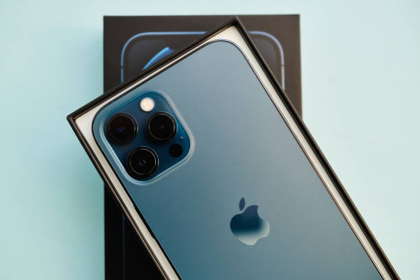 Brand new iPhone 12 Pro Max in Pacific Blue in Studio Setting 17 November 2020 - Peyton, Colorado, USA: A studio shot of a brand new iPhone 12 Pro Max in Pacific Blue in the box it was shipped in. Shot on a pale blue surface iphone stock pictures, royalty-free photos & images