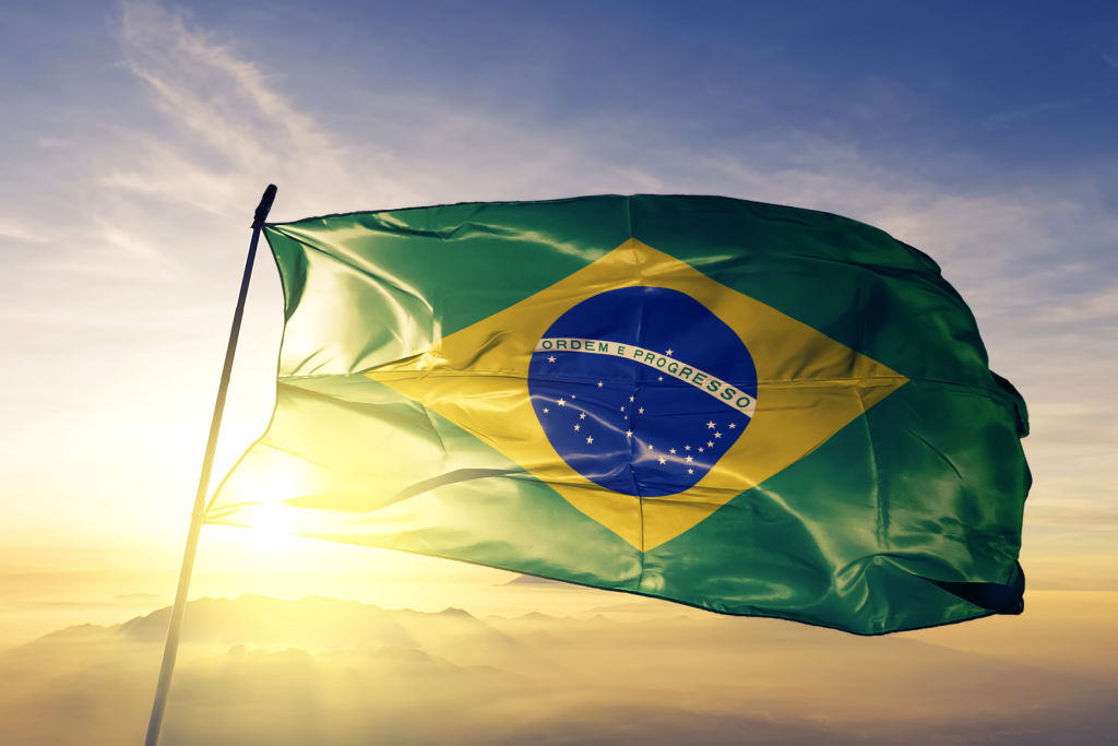 Brazil Brazilian flag on flagpole textile cloth fabric waving on the top sunrise mist fog
