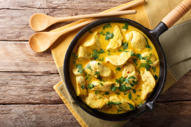 Brazilian food: coconut chicken in a spicy cream sauce close-up. Horizontal top view Brazilian food: coconut chicken in a spicy cream sauce close-up on a table. Horizontal top view from above curry meal stock pictures, royalty-free photos & images