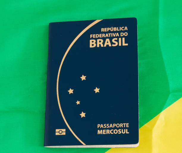 Brazilian passport (Translation "Republic federal mercosul passport") and flag Brazil colors background. stock photo