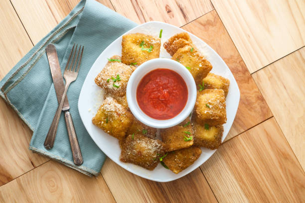 Breaded Fried Toasted Ravioli Breaded fried Italian ravioli with hot marinara tomato dipping sauce toasted food stock pictures, royalty-free photos & images