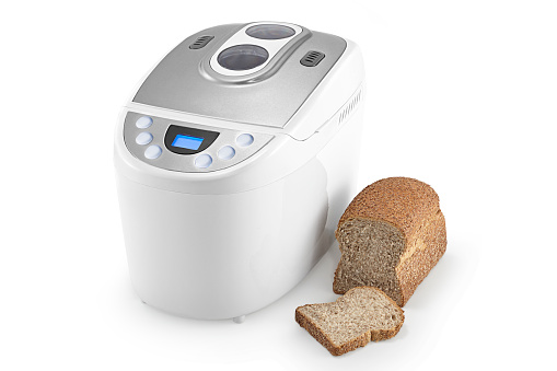 Breadmaker machine and bread on white background