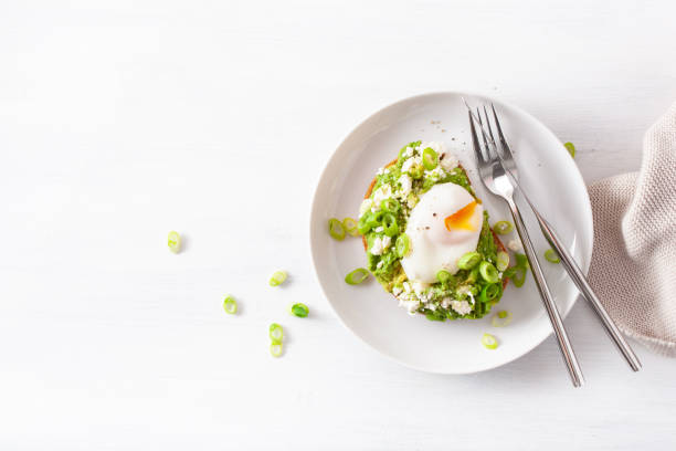 breakfast avocado sandwich with poached egg and feta cheese breakfast avocado sandwich with poached egg and feta cheese poached food stock pictures, royalty-free photos & images