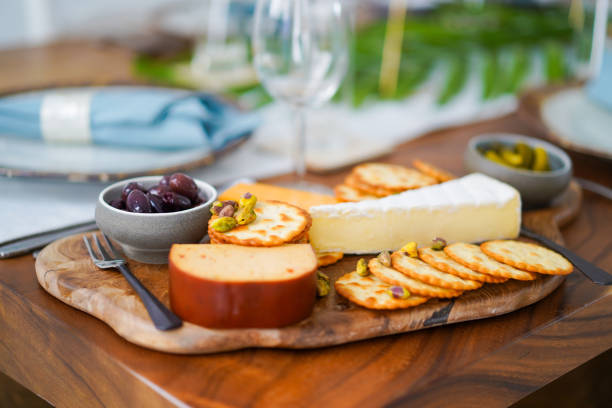 Breakfast on wooden board, spread of cheese and biscuits.  cheese board stock pictures, royalty-free photos & images
